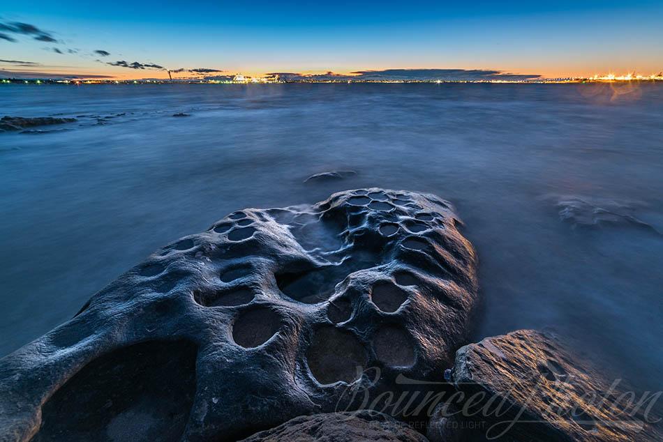 Looking over the Moon-like rocky shore at blue hour at Kurnell, Australia